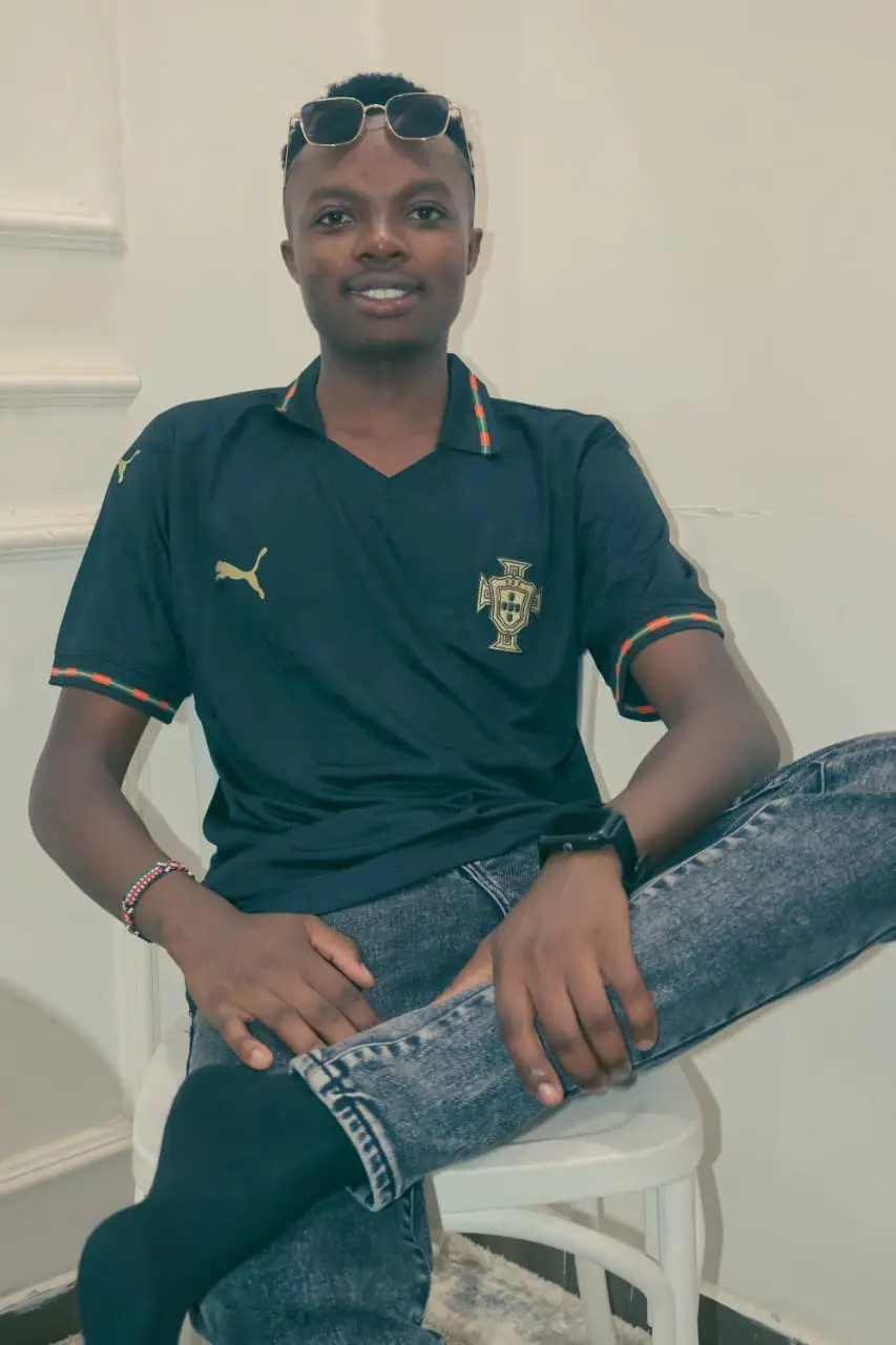 A supporter in the black Portugal jersey, seated and smiling